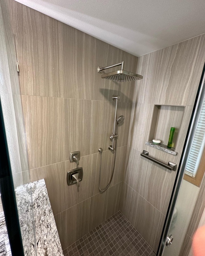 Walk-in shower with rain showerhead and recessed shelf in Salem, OR custom home by Righteous Renovations