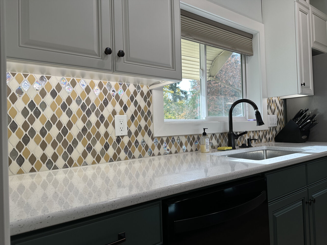 Kitchen sink wall with under-cabinet lighting and colorful backsplash by Righteous Renovations in Salem, OR