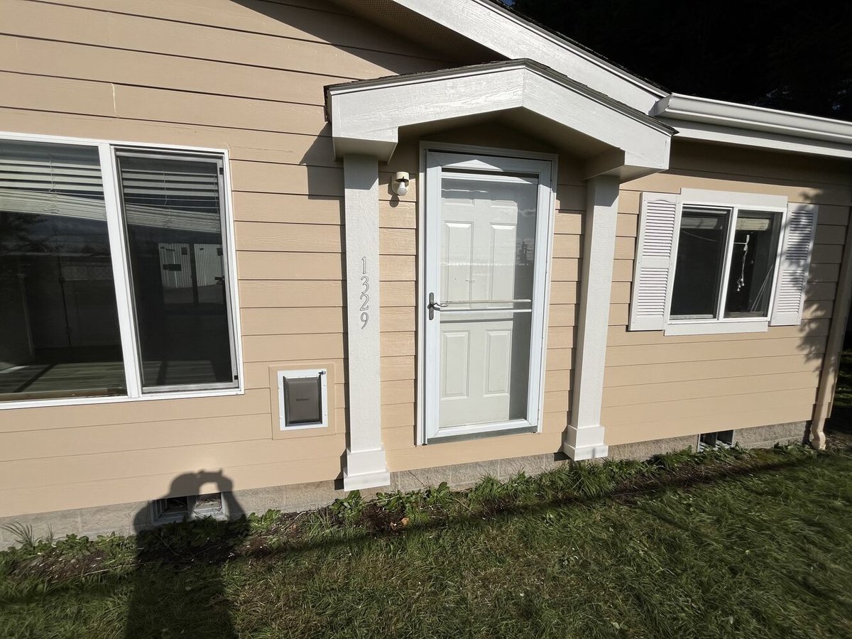 Updated front entry of custom home with white trim and tan siding by Righteous Renovations in Salem, OR