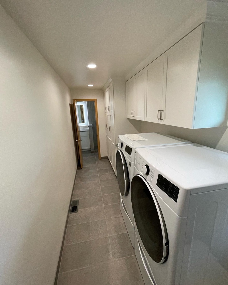 Custom laundry room remodel with front-loading washer and upper cabinets by Righteous Renovations in Salem, OR