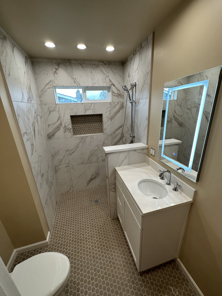 Full view of custom bathroom with walk-in shower and marble-look tile by Righteous Renovations in Salem, OR