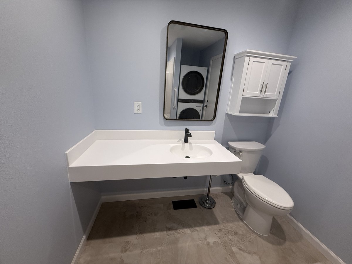Minimalist bathroom design featuring wall-mounted vanity and storage cabinet in a custom home in Salem, OR by Righteous Renovations