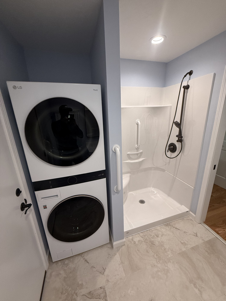 Open bathroom design with wall-mounted sink and textured flooring by Righteous Renovations in Salem, Oregon