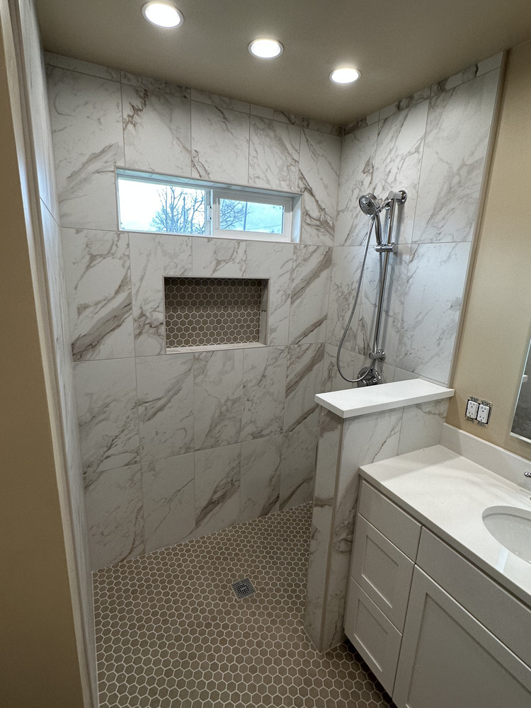 Recessed tile shower niche with hex tile accent in a custom bathroom remodel by Righteous Renovations in Salem, OR