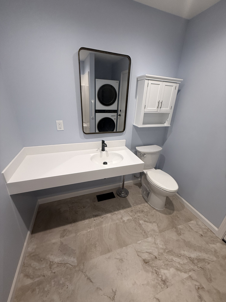 Renovated bathroom with white floating sink and stackable laundry unit in a Salem, OR custom home by Righteous Renovations