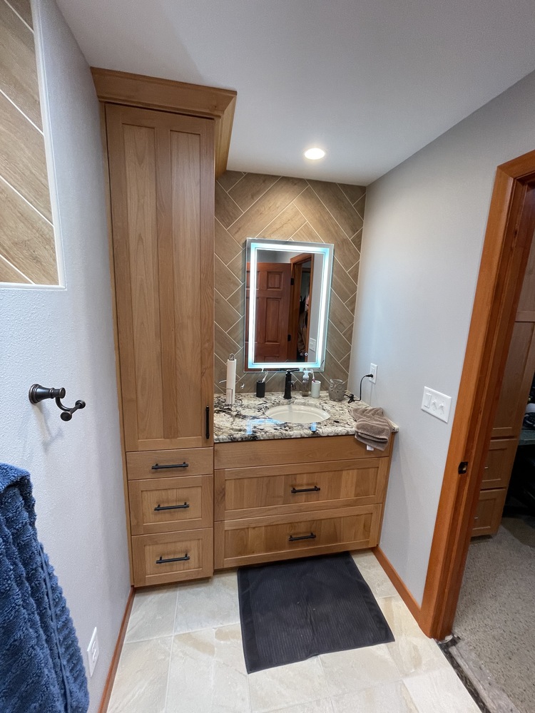Custom bathroom vanity with granite countertop and herringbone backsplash by Righteous Renovations in Tualatin, OR