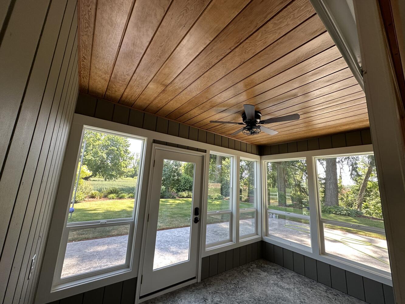 Custom-built enclosed patio with panoramic windows and wood panel ceiling by Righteous Renovations near Turner, OR