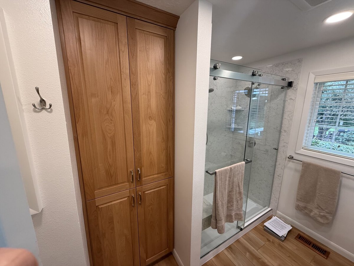 Custom storage cabinets and frameless glass shower in bathroom remodel by Righteous Renovations in Corvallis, OR