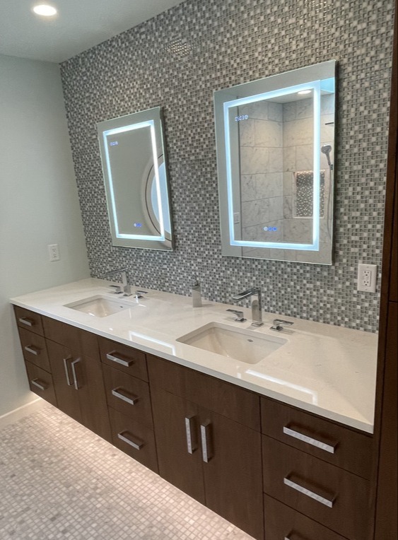 Double vanity with backlit mirrors and mosaic tile backsplash in a Righteous Renovations custom home in West Linn, OR