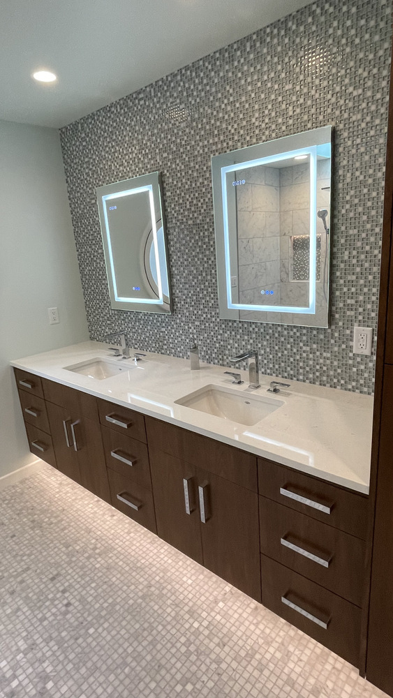 Double vanity with backlit mirrors and mosaic tile backsplash in a Righteous Renovations custom home in West Linn, OR