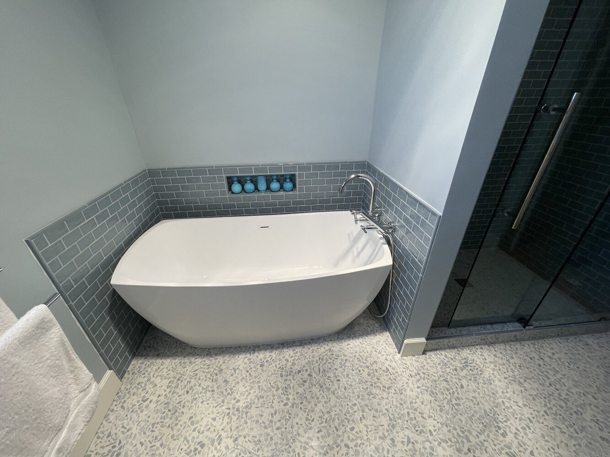 Freestanding bathtub with blue accent tile and wall niche in Salem, OR custom home by Righteous Renovations