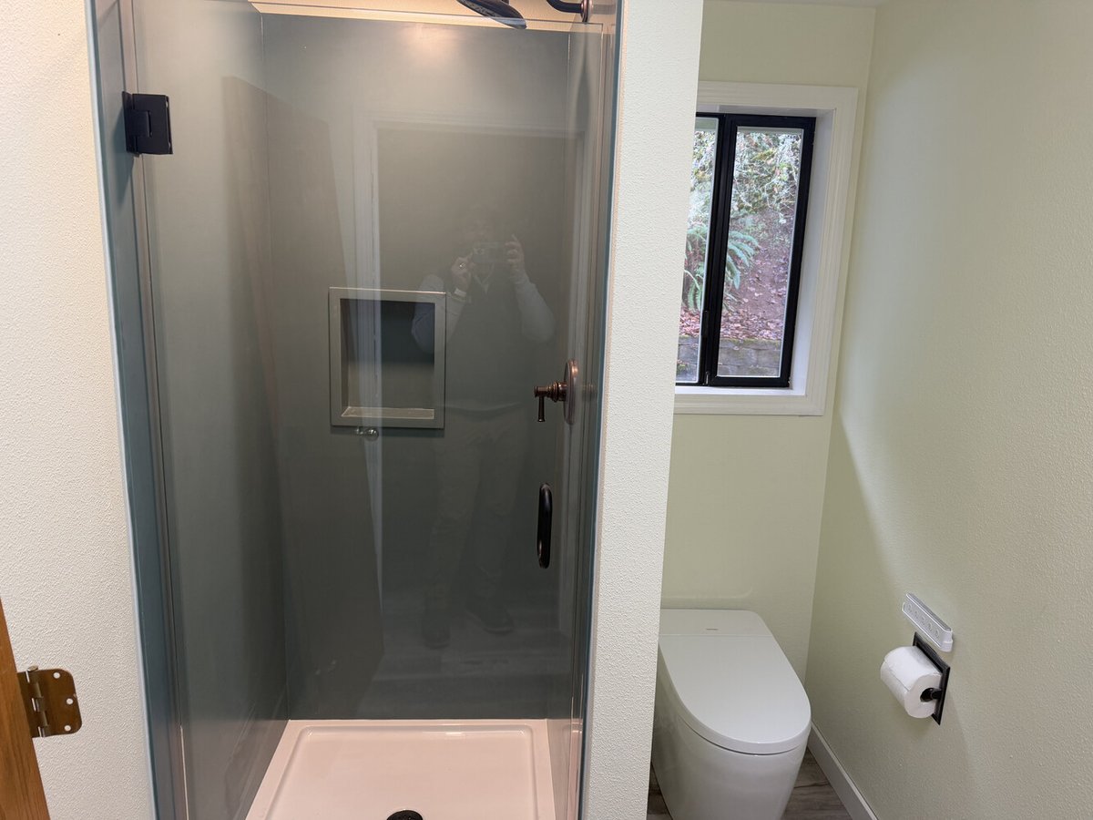 Compact custom bathroom with frameless glass shower and modern toilet by Righteous Renovations in Salem, OR