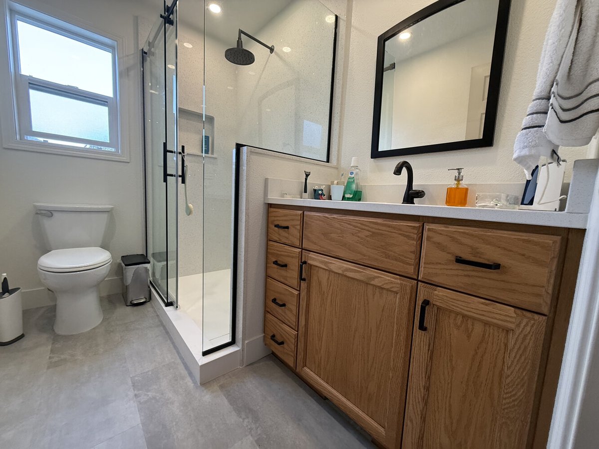 Full bathroom remodel with walk-in shower and wood vanity by Righteous Renovations in Salem, OR