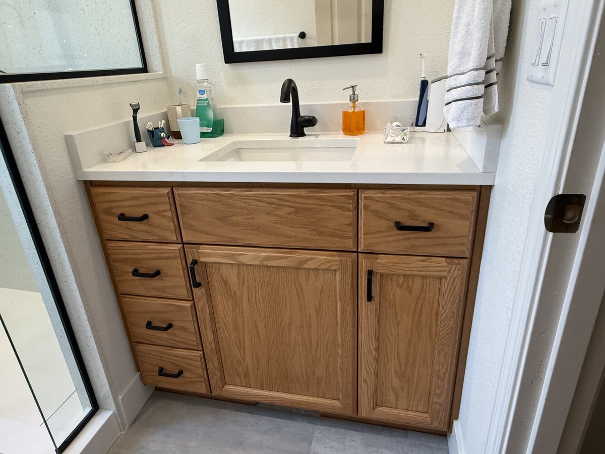 Oak vanity with chrome fixtures and decor in a Salem, OR home by Righteous Renovations