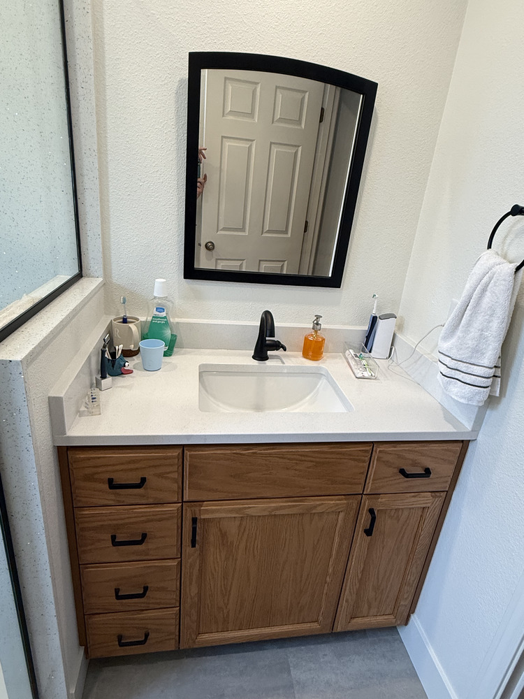 ingle-sink vanity with quartz countertop and black framed mirror by Righteous Renovations in Salem, OR