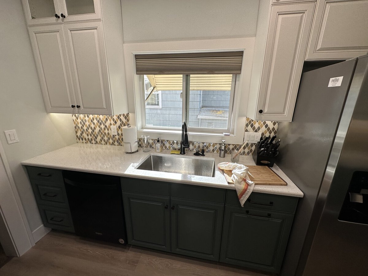 Elegant kitchen design with dual-tone cabinetry and window above sink by Righteous Renovations in Salem, Oregon
