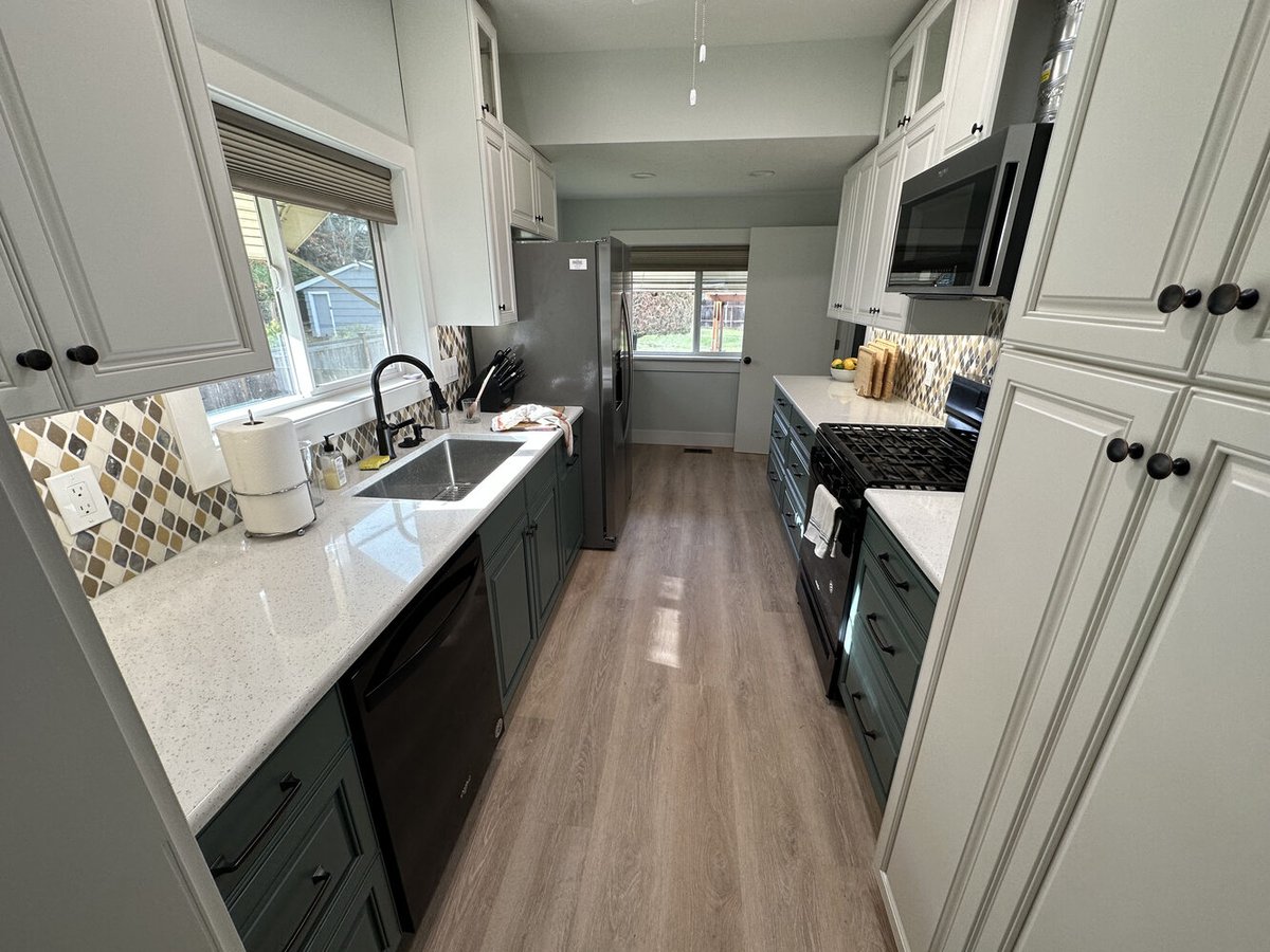 Full view of galley-style kitchen with quartz counters and wood-look floors by Righteous Renovations in Salem, OR