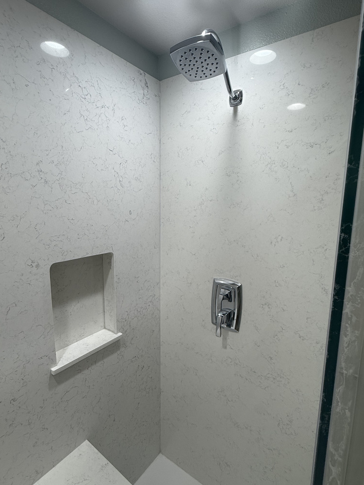 Chrome rainfall showerhead and inset shelf in a custom walk-in shower by Righteous Renovations in Salem, Oregon