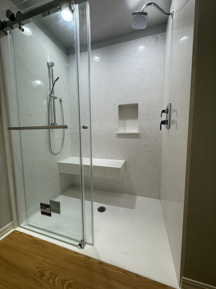 Full view of a custom shower enclosure with sliding glass doors and quartz walls in Salem, OR by Righteous Renovations
