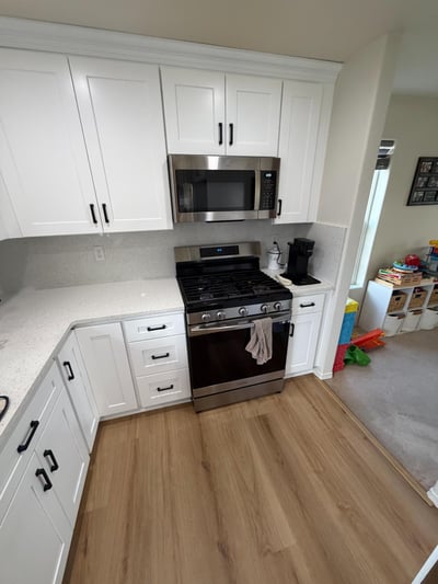 Corner kitchen with new shite shaker cabinets and playroom.