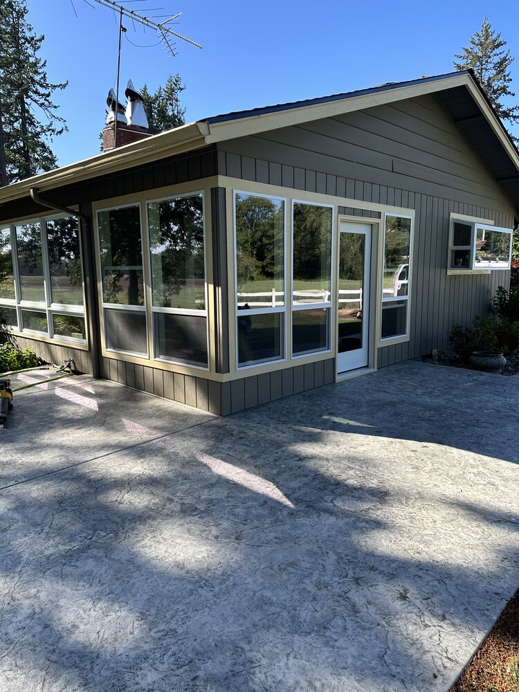 Exterior view of a custom sunroom addition with large windows by Righteous Renovations in Sheridan, OR