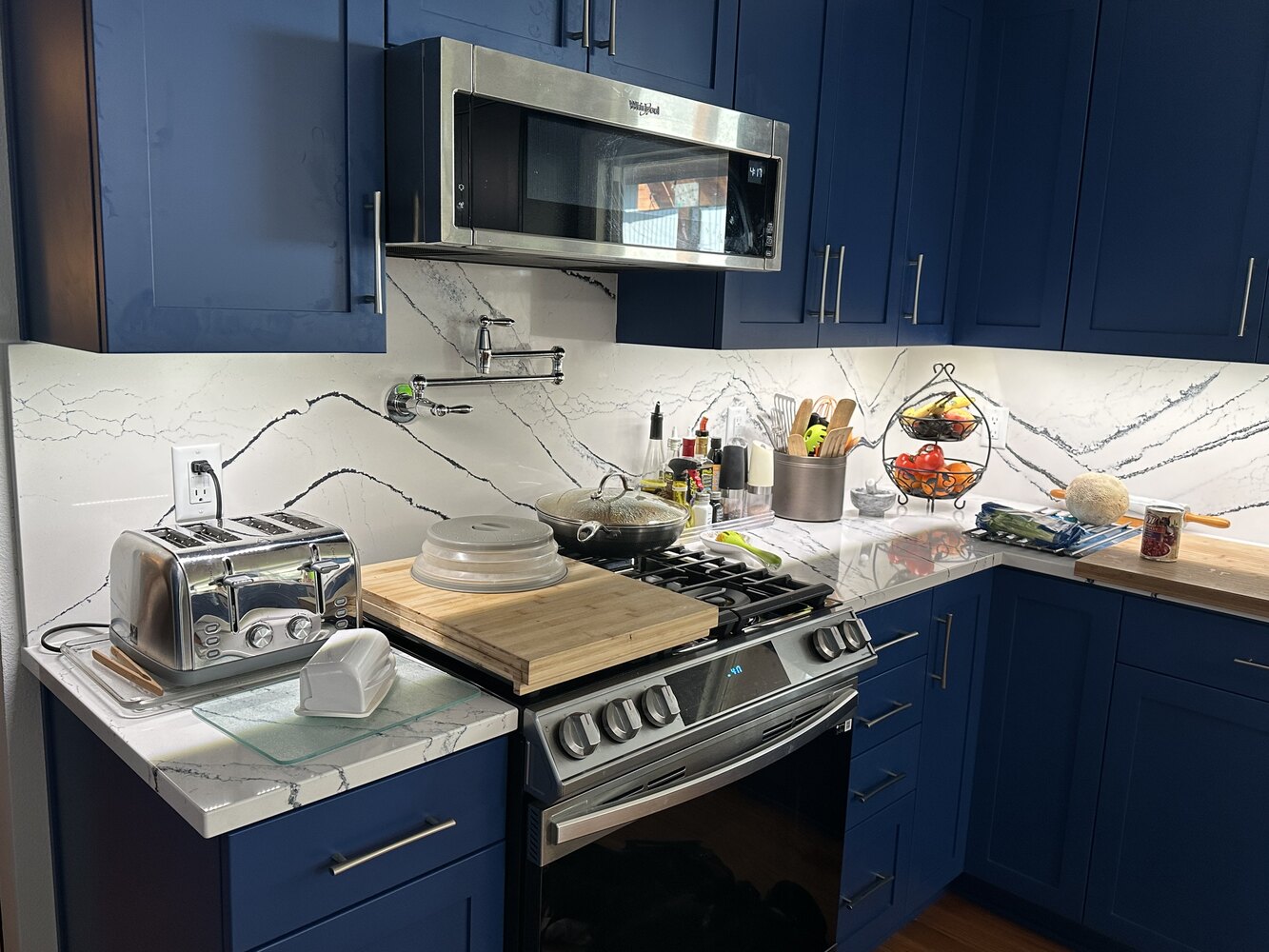 Righteous Renovations custom kitchen remodel featuring bold blue cabinets and white marble backsplash in Salem, OR